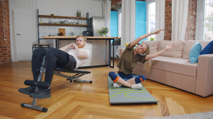 Young lovely couple doing workout at home together