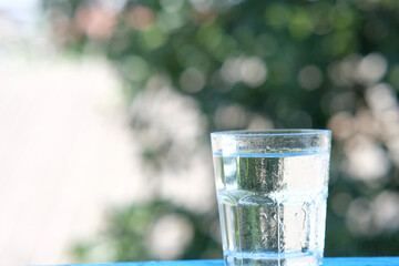 glass of water on wood table background and pouring drinking water