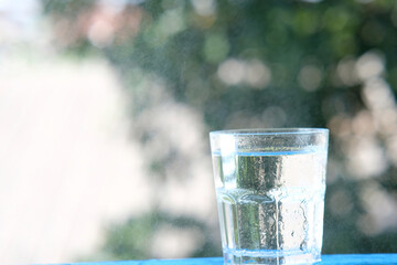 glass of water on wood table background and pouring drinking water