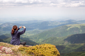 Naklejka premium Traveling in nature, woman photographing landscape.