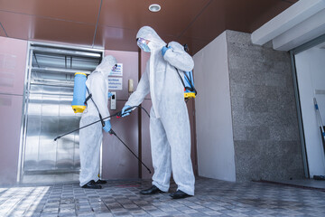 Man in virus protective suite and mask spraying alcohol cleaning covid19 infected area, Virus disinfection concept