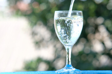 glass of water on wood table background and pouring drinking water