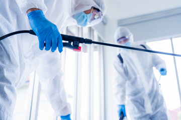 Man in virus protective suite and mask spraying alcohol cleaning covid19 infected area, Virus disinfection concept