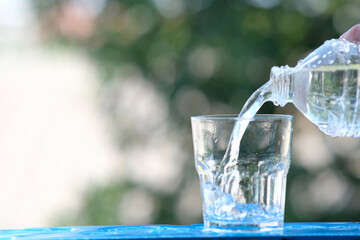 glass of water on wood table background and pouring drinking water