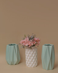 artificial flowers in decorative vase on beige background