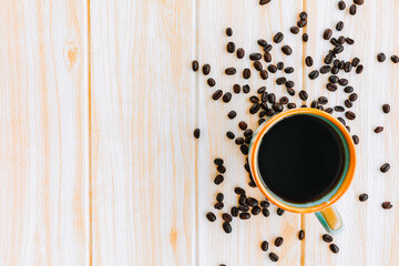 Cup of coffee and coffee beans on wooden background, top view, copy space