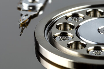 Macro shot of a magnetic needle on a hard disk platter, open HDD disk, perfectly clean surface.