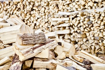 Stacked firewood close-up. Firewood storage close up. Stocks of wooden logs close-up. Chopping wood. Logging in the village. Rustic lifestyle. Woodpile with firewood full frame image. Wooden texture.