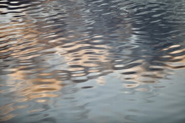 Silver surface of calm water with golden highlights and reflections. Beautiful glowing ripples on water surface close-up. Silver metal surface with abstract pattern close-up. Abstract texture.