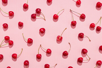 Flat lay of cherries on a pink background. - obrazy, fototapety, plakaty
