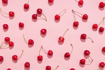 Foto op Plexiglas Flat lay of cherries on a pink background. © Melica