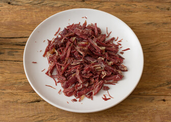 Fototapeta premium Food plate with jerk beef. Dish showing braziliand way of preparing meat. On rustic wooden table.