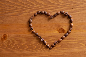 Heart formed by coffee beans on wood