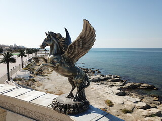 Statue flying horse pegasus a greek mythology figure on the roof of amphitheater in Aktau,...