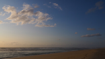 Coucher de soleil sur la plage, avec un cumulus dans le ciel