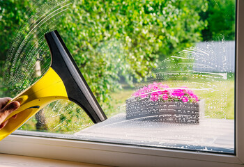 Cleaning windows with portable professional vacuum cleaner.