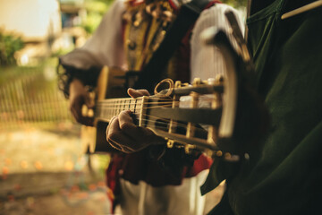 Performer with a beautiful costume playing an acoustic guitar in a backstage of a theatrical show