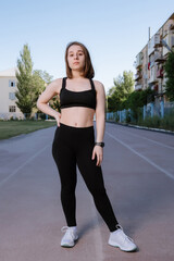 Portrait of attractive sport woman in sportswear posing outdoors at the stadium.