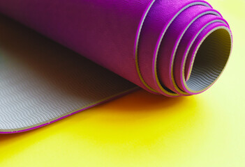 Bright purple yoga mat on a yellow background