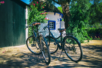 2 bicycles parked in front of a circular house. Nice cottage-shaped country house.