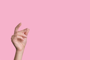Female beautiful caucasian hand snaps fingers. pink background.