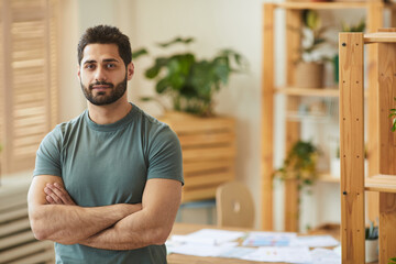 Fototapeta premium Waist up portrait of handsome bearded man looking at camera while standing with arms crossed in home office interior, copy space