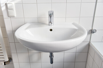 Ceramic sink in the bathroom with faucet and tiles