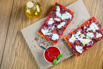 Pizza with tomato, prosciutto, sour cream and olive oil