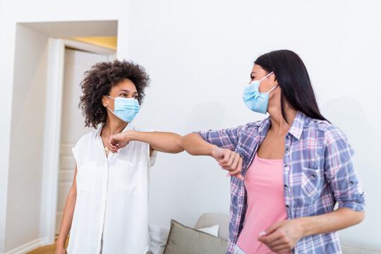 Friendly Smiling Millennial Diverse Female Colleagues Keeping Social Distance, Greeting Each Other By Bumping Elbows Instead Of Hugs Or Handshaking, Preventing Covid 19 Coronavirus Infection Spread.