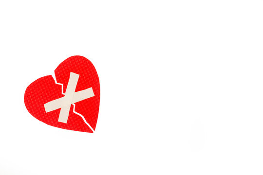 Corazón rojo con vendaje adhesivo sobre un fondo blanco liso y aislado. Vista superior. Copy space