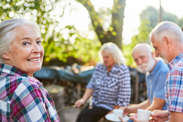 Gruppe Senioren im Garten beim Kaffee trinken