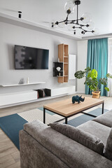 Modern Living Room .Grey sofa ,carpet and curtains.Modern floor lamp. Wooden coffee table.White cyan colors.