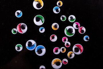 Colorful googly eyes on a black background