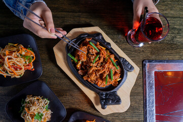 Asian lunch with meat, salads and lemonade on table