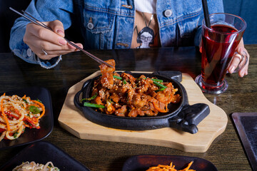 Asian lunch with meat, salads and lemonade on table