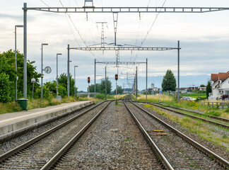 Fototapeta premium view of the train tracks leading off into the horizon at Altnau train station