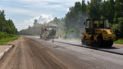 Asphalt paver and roller machine. Road repair works on the suburb highway