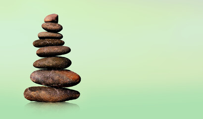Fototapeta na wymiar Stone-stacking or rock balancing with green background
