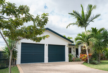 Newly painted house with double garage and tropical garden