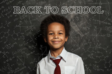 African American school child student on blackboard background with science and maths formulas....