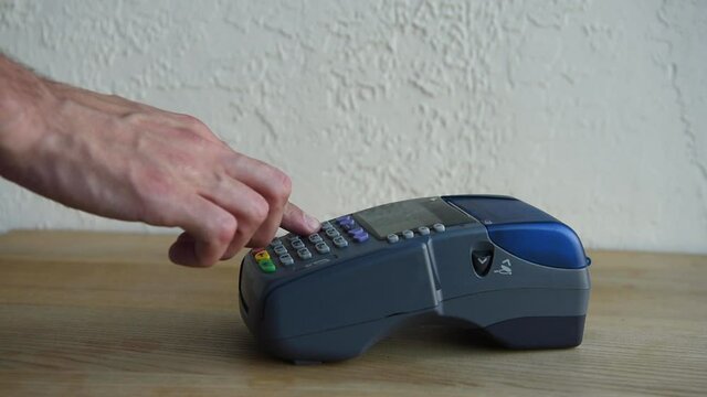 cropped view of man pushing buttons on payment terminal