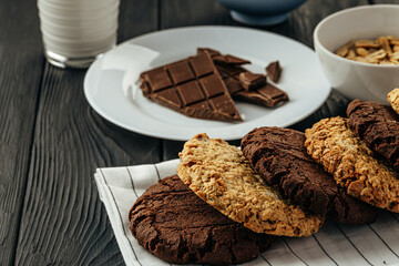 Chocolate and oat cookies on dark wooden table