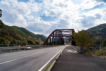 Road is going to mountain via bridge in Japan.