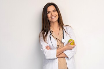 medical doctor woman smile with stethoscope hold dreen fresh apple in hand. Isolated over white background.