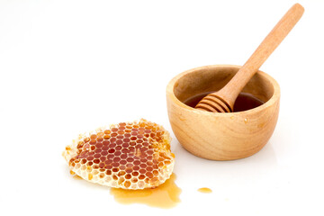 Honeycomb with honey dipper isolated on white background