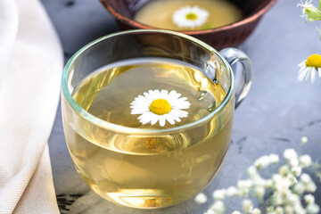 Transparent cup of hot chamomile tea and honey. Concept of a healthy soothing herbal drink after a hard day or in the morning