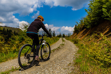 Fototapeta na wymiar Cycling woman on mtb bike on gravel mountain road, Beskidy, Poland.
