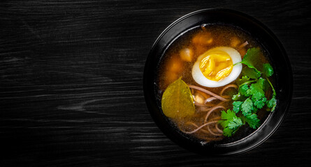 Japanese ramen soup with tofu and egg on black wooden table background