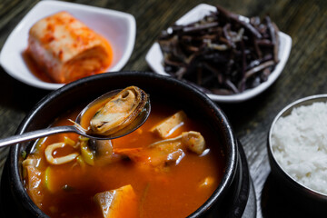 Hot asian soup with sea food. Mussels in spoon