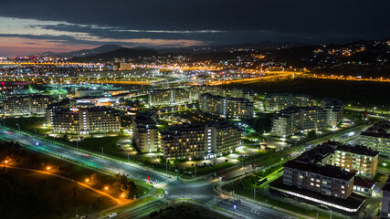 Fototapeta premium Night city. Evening lighting of the building. Residential area of the city. Sochi Olympic Park. Sunset. Multi-storey building.